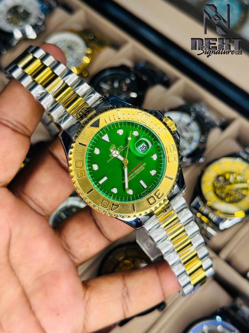 Rolex Yacht-Master watch with a distinctive green dial and a two-tone gold and steel bracelet..